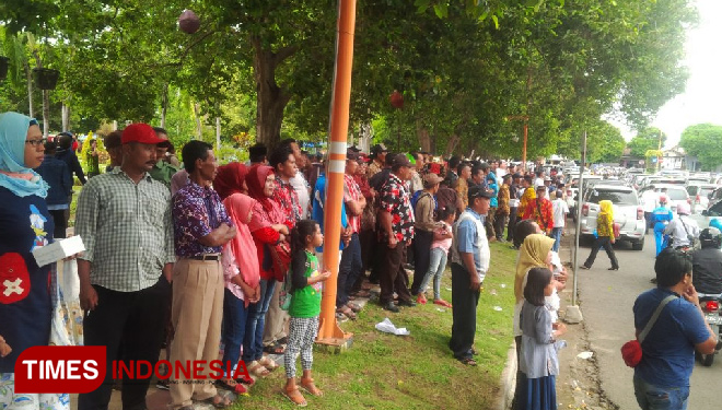 Ribuan warga berdiri di Taman Sritanjung melihat proses pelantikan kepala desa mereka dari jauh, yang digelar di dalam Pendopo Sabha Swagata Blambangan. (FOTO: Ahmad Suudi/TIMES Indonesia)