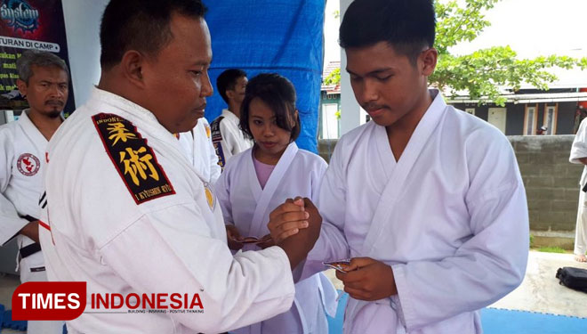 Ketua Dewan Pelatih Bontang Sersan Mayor Eko Budi Setiawan saat memberikan selamat pada peserta atas kenaikan sabuknya. (Foto: Norkem Kodim Bontang for TIMES Indonesia)