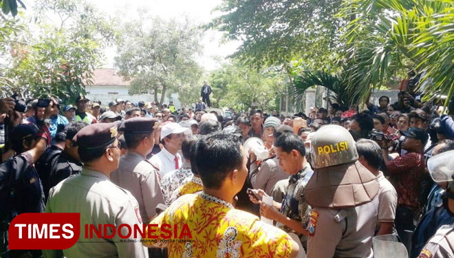 Pihak Panitera Pengadilan Negeri Banyuwangi (batik kuning) dan aparat Kepolisian mendapat hadangan dari massa pendukung H Moh Shoheh di Lingkungan Karanganyar, Kelurahan Karangrejo, Kecamatan/Kabupaten Banyuwangi beserta penasehat hukumnya (FOTO: Hafil Ah