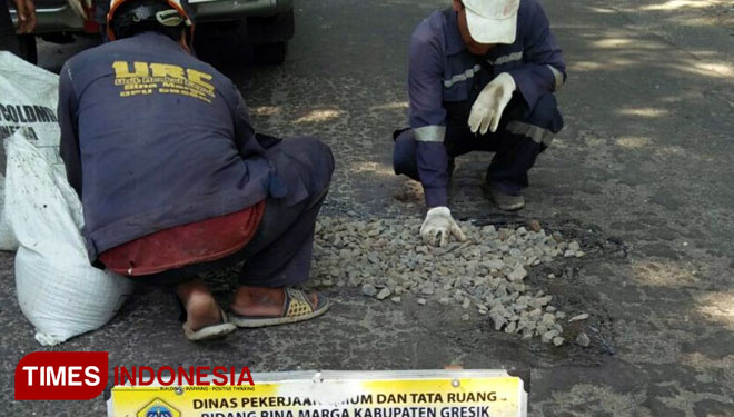 Tim unit reaksi cepat (URC) bidang bina marga Dinas Pekerjaan Umum dan Tata Ruang Bidang Binamarga sedang melakukan perbaikan jalan di Desa Sawo, kecamatan Dukun, Gresik. (FOTO: Akmal/TIMESIndonesia)