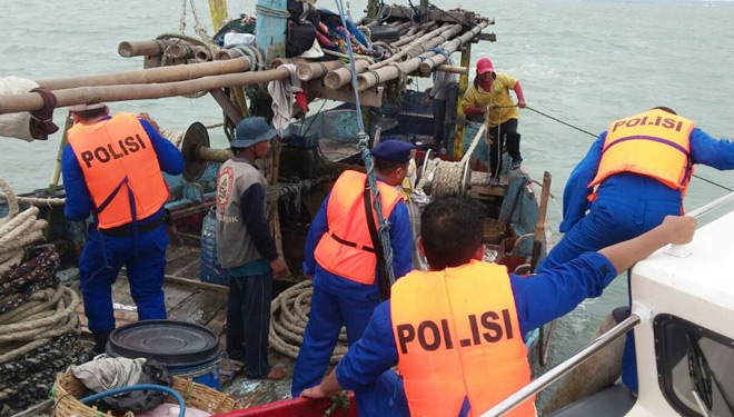 Anggota Satpolair Polres Bangkalan saat memeriksa kapal nelayan Pasuruan yang diamankan di wilayah perairan Kwanyar. (FOTO: Istimewa)