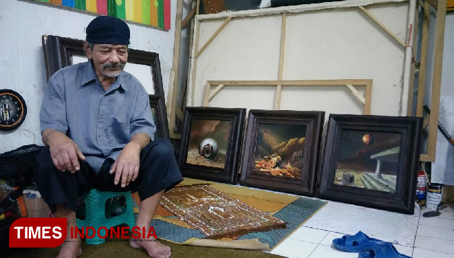 Soemo Gambar bersama sejumlah lukisannya. Ia terus melukis walau usianya makin senja. (FOTO: Widodo Irianto/TIMES Indonesia)