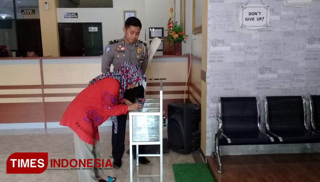 Kanit Regident Satlantas Polres Pasuruan, Iptu Yudhi Anugrah Sik,MH saat mendampingi seorang wajib pajak mengisi IKM. (FOTO: Robert/ TIMES Indonesia)