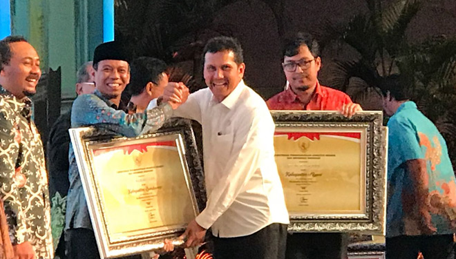 Men PAN RB, Asman Abnur, saat menyerahkan penghargaan kepada Bupati Bondowoso, Amin Said Husni, di Nusa Dua Bali. (FOTO: Istimewa)