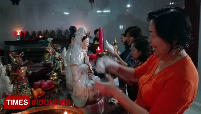 Ibu-ibu membersihkan patung di Klenteng Kwan Im Tong, Kota Batu, Senin (5/2/2018). (FOTO: Ferry/TIMES Indonesia)