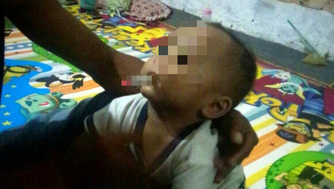Foto balita berumur 9 bulan yang diberi rokok dan diunggah ke akun facebook. (FOTO: Istimewa)