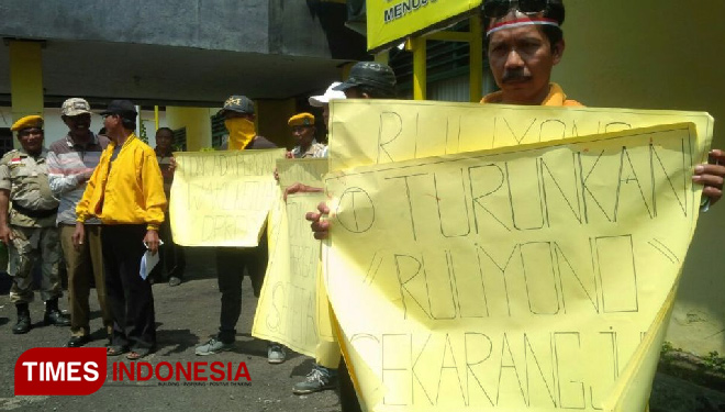 Massa kader militan Partai Golkar Banyuwangi, membeber poster tuntutan pemecatan ketua DPD, Ruliyono. (FOTO: Syamsul Arifin/TIMES Indonesia)