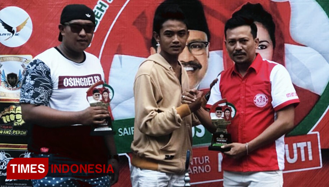 Ketua Panitia pameran dan lomba burung berkicau Piala Gusti, Tri Sudaryono saat menyerahkan piala kepada pemenang. (FOTO: Dian Efendi/TIMES Indonesia)