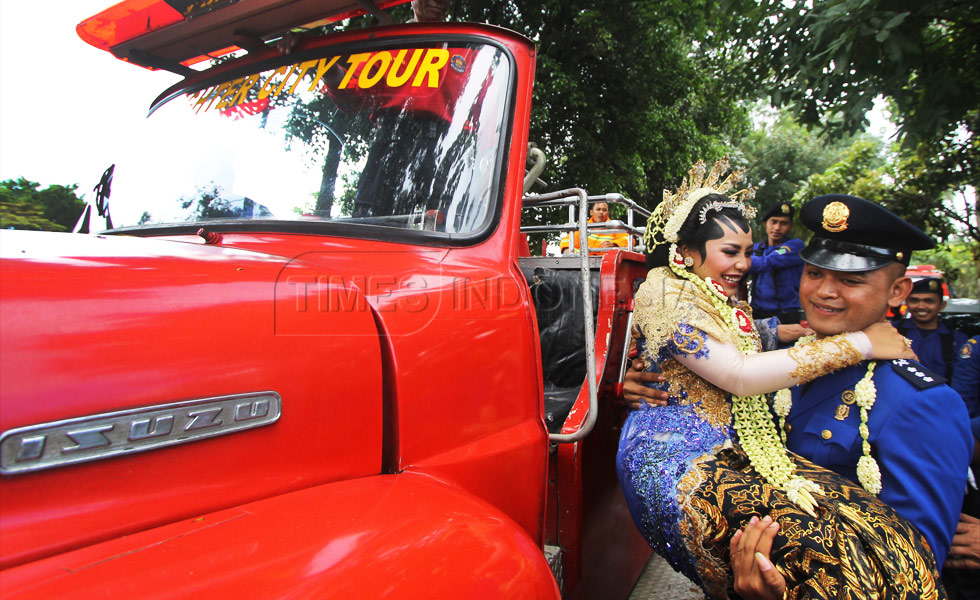 Anggoro Setyo Pramono (25) menggendong Novia Nur Eka Saputri (25) untuk naik mobil Brand weer untuk diarak keliling (FOTO : Adhitya Hendra/TIMES Indonesia)