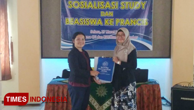 Kepala Humas Universitas Muhammadiyah Jember Nurul Fathiyah Fauzi (kanan) menyerahkan cinderamata kepada perwakilan IFI-CFI Astrini Simanjuntak dalam sosialisasi beasiswa ke Prancis. (FOTO: Mohammad Aidi/TIMES Indonesia)