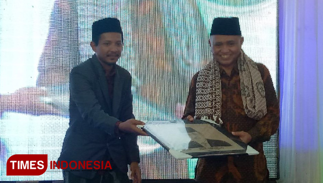Ketua KPK Agus Raharjo ketika menerima cinderamata dari Ketua Umum Mubes I Alumni dan Simpatisan Syaichona Moh Cholil (Asschol), KH Nasih Aschal. (FOTO: Doni Heriyanto/TIMES Indonesia)
