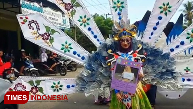 Salah satu santri wati memamerkan busana hasil kreatifitas berbahan plastik dan kertas bekas dalam Darussalam Ethno Carnival Al Khodijah. (FOTO: Syamsul Arifin/ TIMES Indonesia)