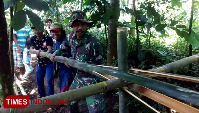 Warga Karangjambu dan Satgas TMMD Purbalingga membelah bambu untuk digunakan warga sebagai kerajinan tangan (FOTO: AJP TIMES Indonesia)