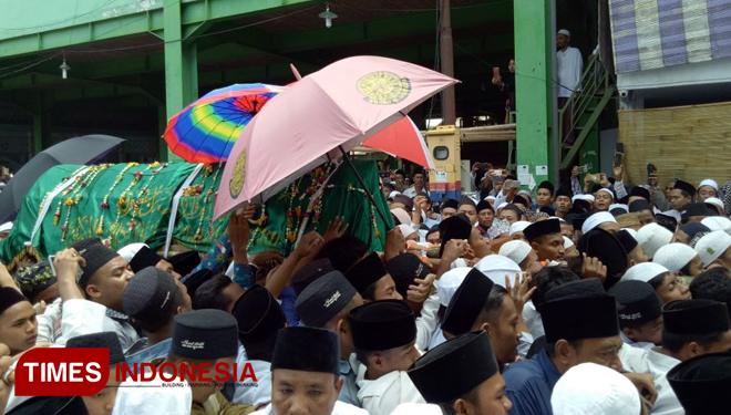 Ribuan warga saling berebutan mengusung jenazah KH Kholirurrahman ketika diberangkatkan dari Ponpes Syaichona Moh Cholil Demangan menuju pemakakaman di Desa Martajasah.(FOTO: Doni Heriyanto/TIMES Indonesia)