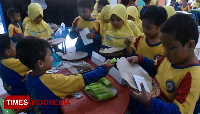 Siswa kelas satu SD Muhammadiyah Manyar sedang mengkonsumsi makanan tradisional (FOTO : Akmal/TIMES Indonesia)