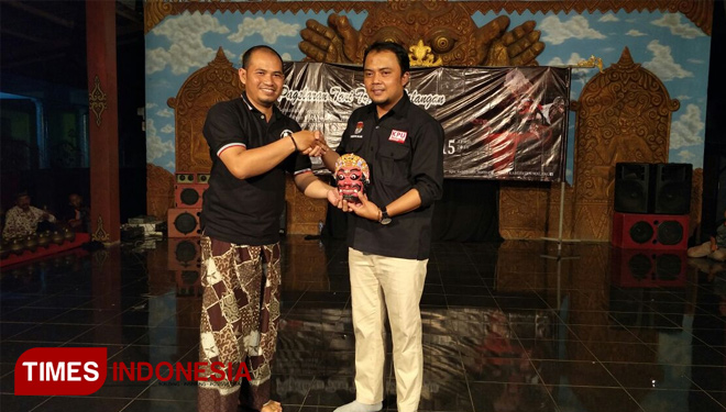 Pimpinan Padepokan Sebi Topeng Kedungmonggo, Tri Handoyo memberikan cinderamata topeng kepada Ketua KPU Kabupaten Malang Santoko SPd. (FOTO: Widodo irianto/TIMES Indonesia)