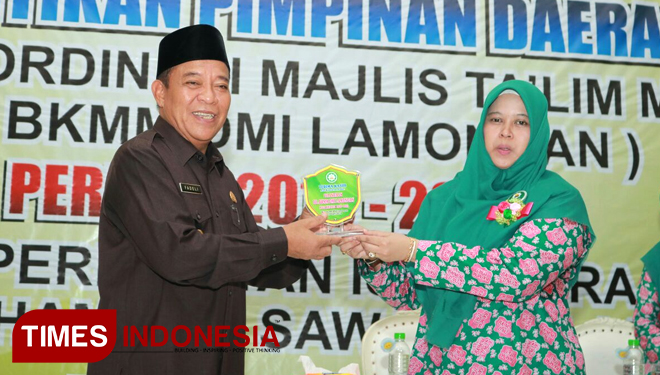 Ketua PD BKMM DMI Lamongan, Nurotun Mumtahanah menerima cinderamata dari Bupati Lamongan Fadeli di sela-sela pelantikan, di Gedung IPHI, Kamis (19/4/2018). (FOTO: Ardiyanto/TIMES Indonesia)