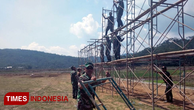 Satgas TMMD saat memasang kerangka bilboard untuk persiapan Upacara penutupan TMMD (FOTO: ajp.TIMES Indonesia)