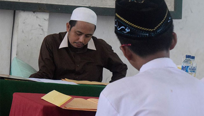 KH. Najiburrahman Wahid mengetes kemampuan baca kitab kuning pelajar MA Nurul Jadid (FOTO: manuruljadid.sch.id)