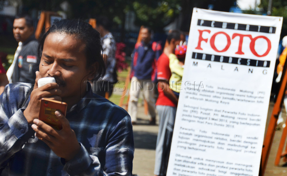 Falahi Mubarok salah satu anggota PFI Malang yang membacakan puisi rangkaian pembukaan   pameran foto PFI Malang di Alun-alun Merdeka, kota Malang (FOTO : Adhitya Hendra/TIMES Indonesia)