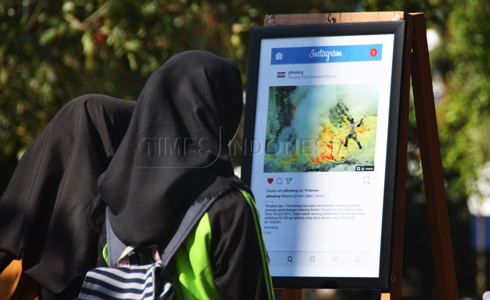Pengunjung melihat karya foto yang dipamerkan oleh PFI Malang di Alun-alun Merdeka, kota Malang (FOTO : Adhitya Hendra/TIMES Indonesia)