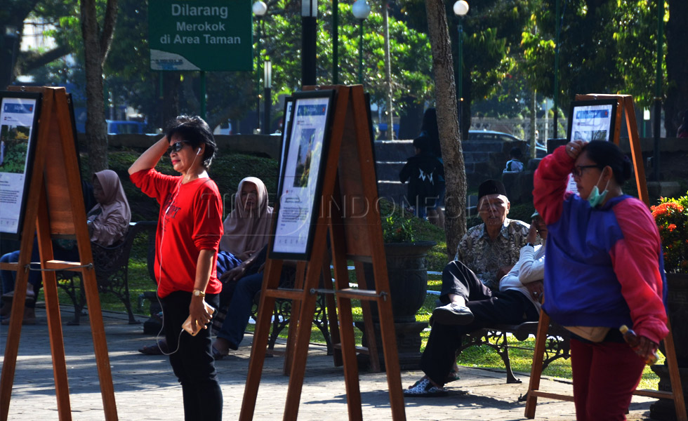 Pengunjung melihat karya foto yang dipamerkan oleh PFI Malang di Alun-alun Merdeka, kota Malang (FOTO : Adhitya Hendra/TIMES Indonesia)