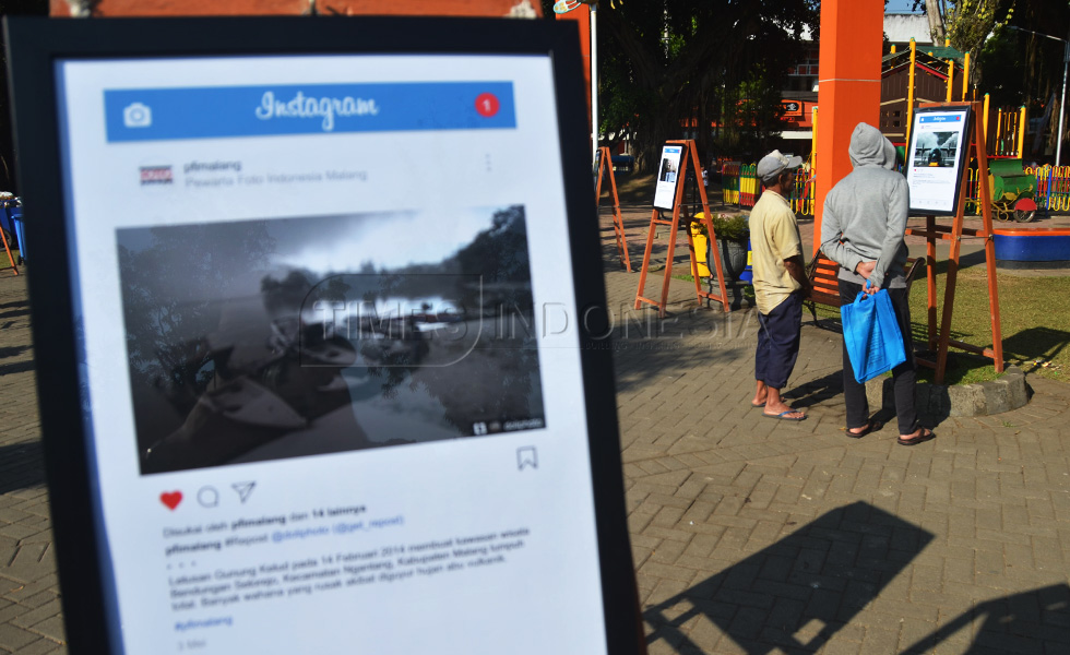 Pengunjung melihat karya foto yang dipamerkan oleh PFI Malang di Alun-alun Merdeka, kota Malang (FOTO : Adhitya Hendra/TIMES Indonesia)