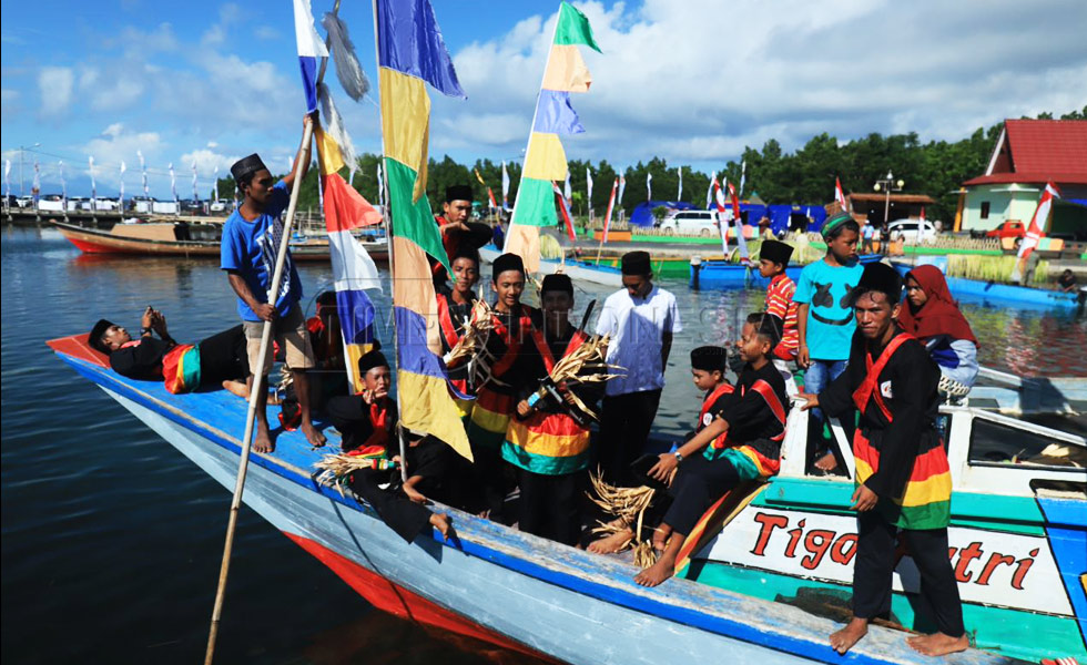 Pemangku adat dan warga berada di atas perahu kora-kora menuju pulau Babua untuk melakukan ritual sigofi ngolo. (FOTO : Derry Indra Lantika)