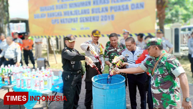 Aparat dari berbagai unsur melakukan pemusnahan ratusan miras di halaman Mapolres Batu, Senin (14/5/2018) siang. (FOTO: Ferry/TIMES Indonesia)