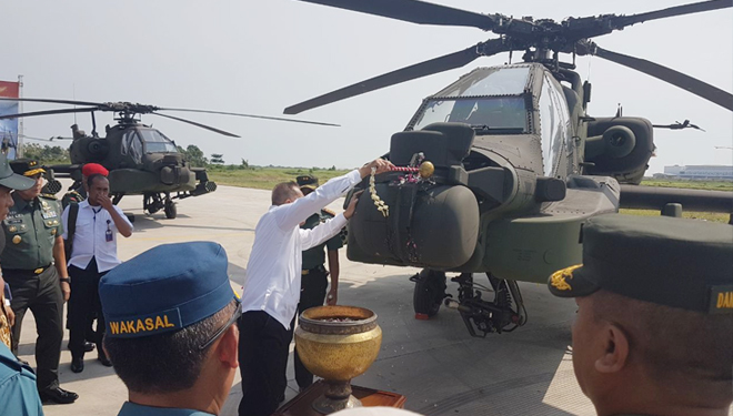 Menhan RI Ryamizard Ryacudu melakukan prosesi siram kembang di badan Apache dalam serah terima penyerahan helikopter AH-64E Apache di Lanud TNI AD Ahmad Yani, Semarang, Jawa Tengah, Rabu (16/5/2018). (FOTO: Istimewa)