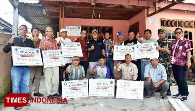 Manager Humas Pupuk Kaltim Wahyudi (baju coklat), Lurah Loktuan Sofyansyah (baju hitam) dan Superintendent Hubungan Eksternal Pupuk Kaltim Ramli (paling kanan) berfoto bersama beberapa Ketua RT penerima Bantuan Papan Nama. (FOTO: Kusnadi/TIMES Indonesia)
