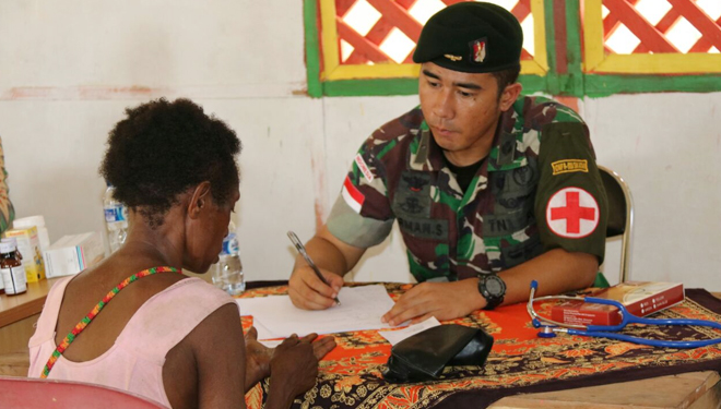 Personel Yonif Raider 500/Sikatan memeriksa kesehatan warga di wilayah perbatasan Papua, Kamis (24/5/2018).(FOTO: Istimewa)