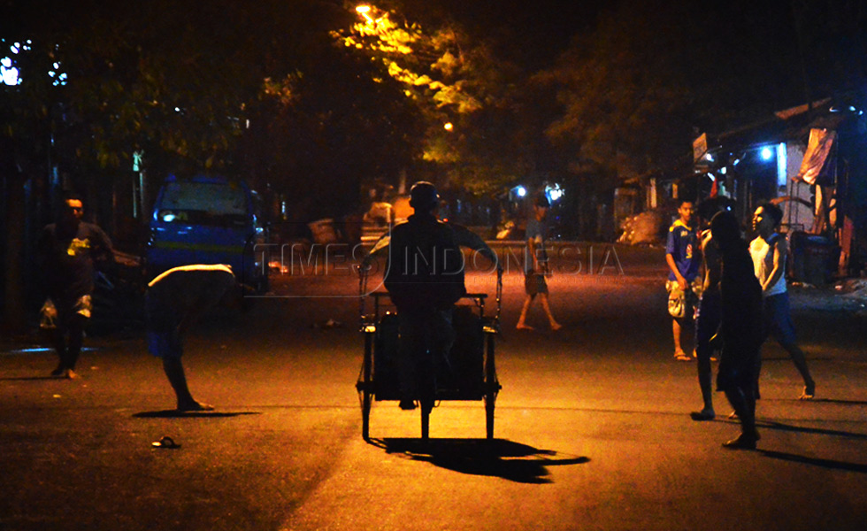 Sebuah becak melintas saat sekelompok kaum muda, bermain sepak bola jalanan di kawasan JL Jagalan kota Malang, (FOTO : Adhitya Hendra/TIMES Indonesia)