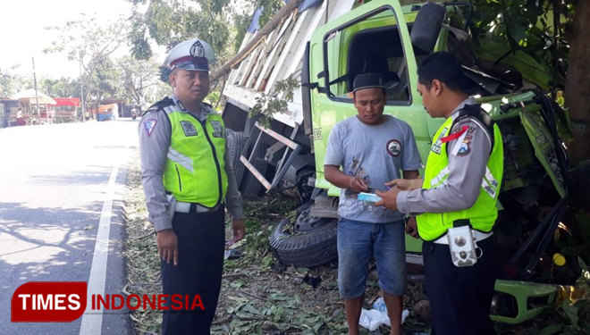 Petugas kepolisian saat mendatangi lokasi truk menabrak pohon. (FOTO :Erwin Wahyudi/TIMES Indonesia)
