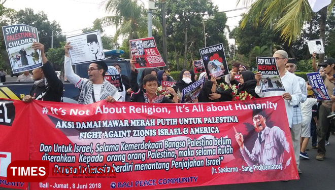 Puluhan orang dari Bali Peace Community, menggelar aksi damai merah putih untuk Palestina Fight Againt Zionis Israel and Amerika. Bertempat, di Denpasar, Jumat (8/6/2018). (FOTO: Khadafi/TIMES Indonesia)