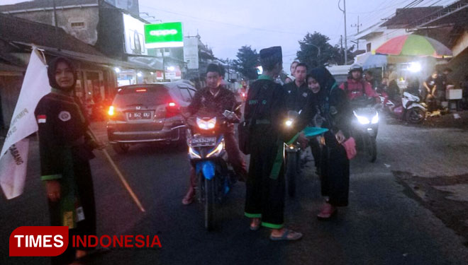 Puluhan pendekar Pagar Nusa sedang melakukan bagi takjil di persimpangan Srono (FOTO : Rizki Alfian/TIMES Indonesia)