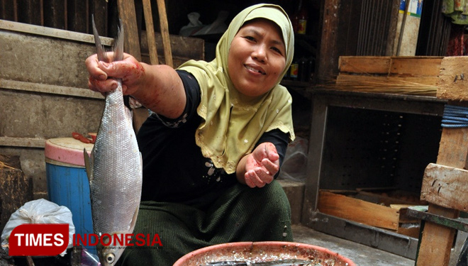 Penjual sedang memamerkan bandeng khas Mengare di pasar bandeng (FOTO : Akmal/TIMES Indonesia).