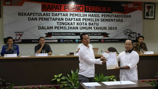 Komisioner KPU Kota Batu, Azhar Chilmi (kanan) menyerahkan berita acara penetapan DPS Pemilu 2019 kepada Ketua Panwaslu Kota Batu, Abdur Rochman, Minggu (17/6/2018) di Samara Resort. (FOTO: KPU Kota Batu)
