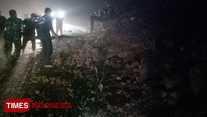 Petugas bersama warga setempat melakukan pembersihan sisa material longsoran. (FOTO: Rizki Alfian/ TIMES Indonesia)