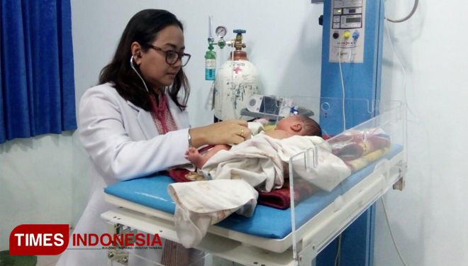 Dokter Natalia saat memeriksa kondisi bayi yang diduga dibuang orang tuanya. (FOTO: Sofy/TIMES Indonesia)
