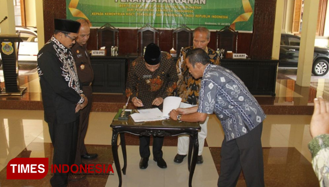 Bupati Bondowoso Drs H Amin Said Husni saat menandatangani berita acara penyerahan barang milik daerah kepada Menristekdikti (FOTO: Moh Bahri/TIMES Indonesia)