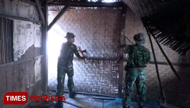 Dua personel TNI sedang membongkar dinding bambu di rumah yang selama ini ditempati Lalu Mohammad Zohri. (FOTO: Anugrah Dan S/TIMES Indonesia)