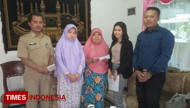 An Operation Area Bisnis PT PPI Boom Marina Banyuwangi, Nurilma Septanti (kedua dari kanan), saat menyerahkan klaim asuransi kepada Hj Samiyah dan keluarga. (FOTO: Syamsul Arifin/ TIMES Indonesia)