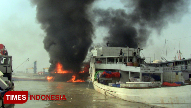 Sebuah kapal pengangkut barang terbakar di Pelabuhan Gresik, Senin (16/7/2018). (FOTO : Akmal/TIMES Indonesia).