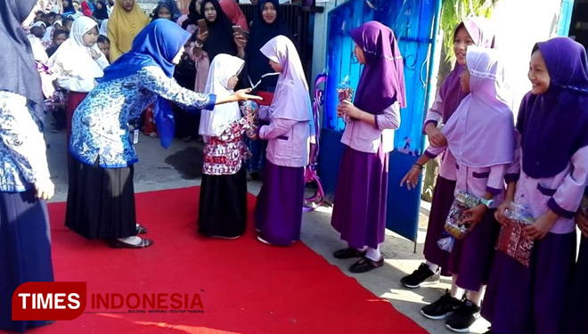 Seorang siswa baru MIM PENA menerima hadiah sajadah kecil dari kakak kelasnya di acara penyambutan siswa baru, Selasa (17/7/3018) (FOTO: MIM PENA for TIMES Indonesia)