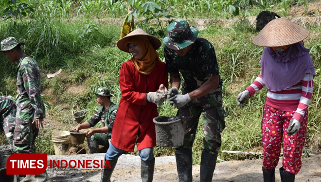 Dengan semangat, ibu-ibu pun turut membantu pengecoran jalan di lokasi TMMD. (FOTO: AJP/TIMES Indonesia)