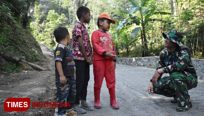 Bayu (10) bersama 2 temannya sedang bertanya kepada anggota Satgas TMMD. (FOTO: AJP/TIMEs Indonesia)
