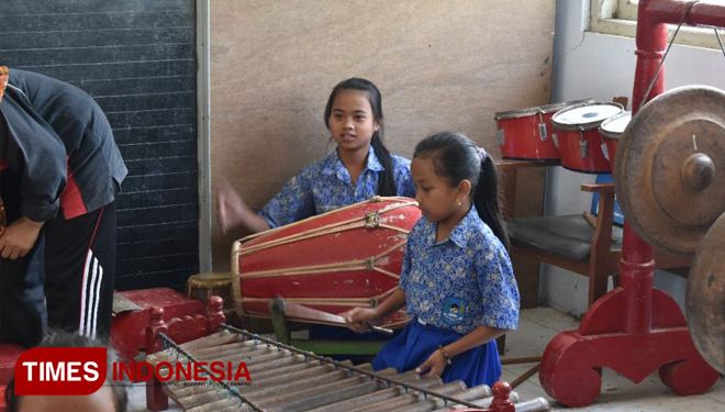 Mutiara (11) siswi kelas V SDN 1 Pasegeran berlatih memainkan kendangnya (FOTO: AJP/TIMES Indonesia)