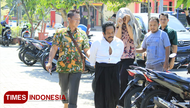 Oknum PNS Pemkab Bangkalan (wajah ditutup jaket) saat digelandang ke Mapolres Bangkalan. (FOTO: Doni Heriyanto/TIMES Indonesia)