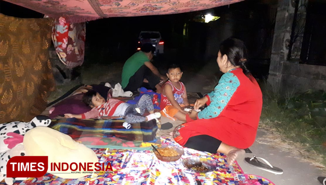 Keluarga Atun Senin (6/8/2018) malam masih masang tenda di Jalan Peternakan Selagalas, Mataram. (FOTO: Abdul Muis/TIMES Indonesia)